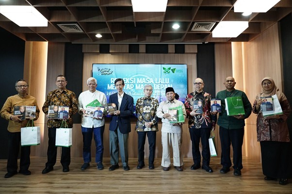refleksijatidiri14 dompet dhuafa Group of ten people on a stage, standing in a line and holding books or folders, posing for a photo at an awards event with a blue banner in the background.