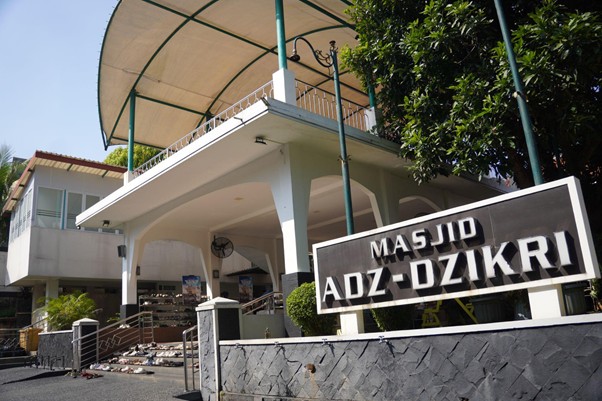 safari dakwah ustaz sugimoto di depok 8 dompet dhuafa Exterior of Masjid Adz-Dzikri with white arches, steps to the entrance, and a prominent black sign in the foreground reading Masjid Adz-Dzikri.