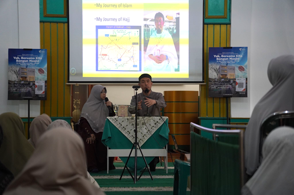 safari dakwah ustaz sugimoto di depok 9 dompet dhuafa Two presenters at a lectern in a mosque, delivering a talk while a projector displays slides about Islam; audience seated in headscarves.