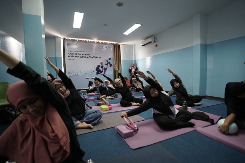 yoga ibu hamil 3 dompet dhuafa Group of women in hijabs doing yoga on mats in a room with a banner in the back reading'A Great Generation Without Stunting, Yes We Can'.